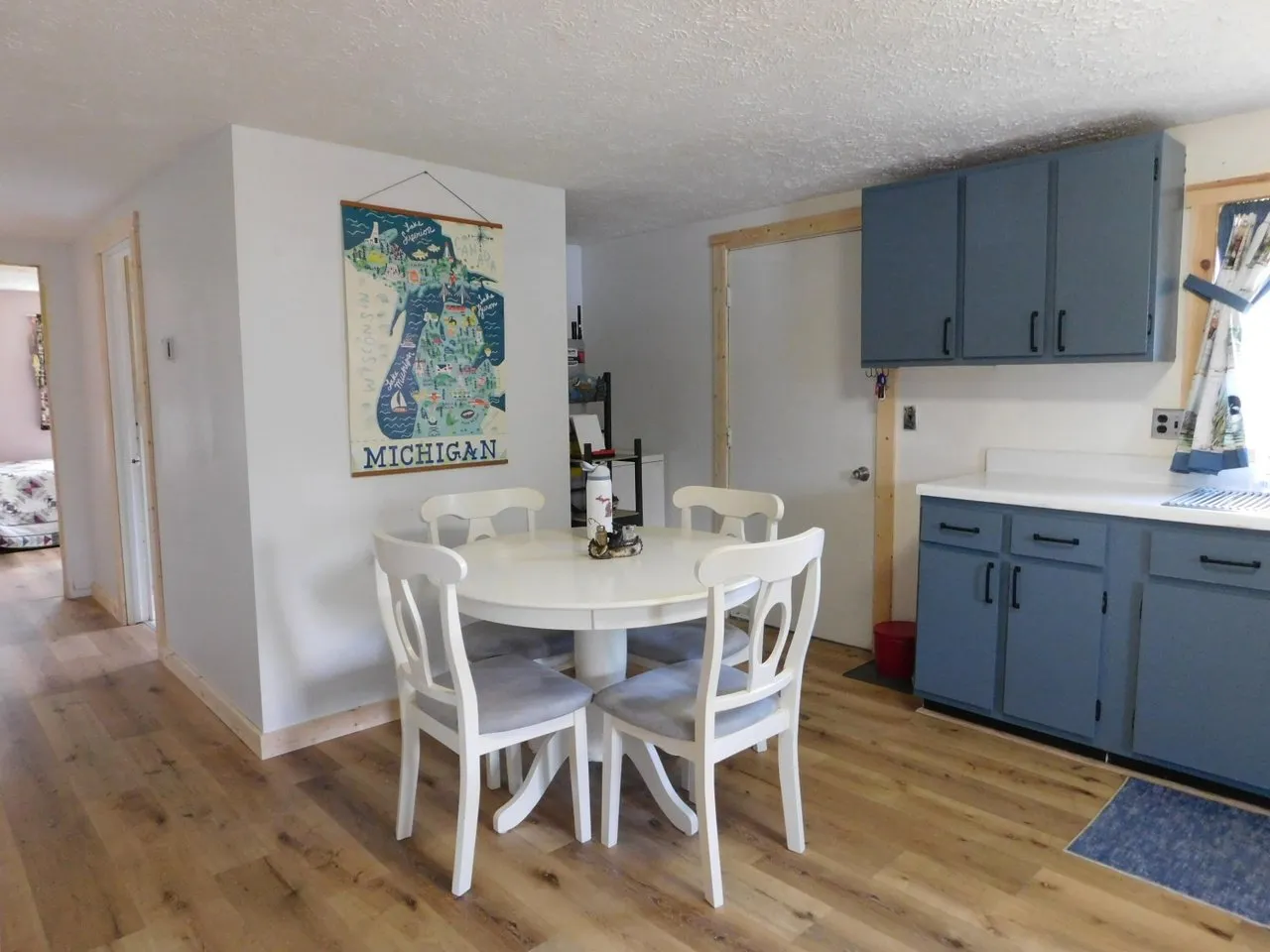 The dining area with a white table and blue kitchen cabinets