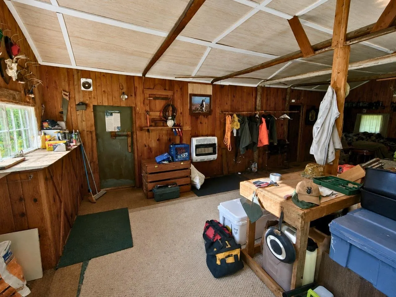 The interior with the propane wall furnace, coat hooks and a work bench