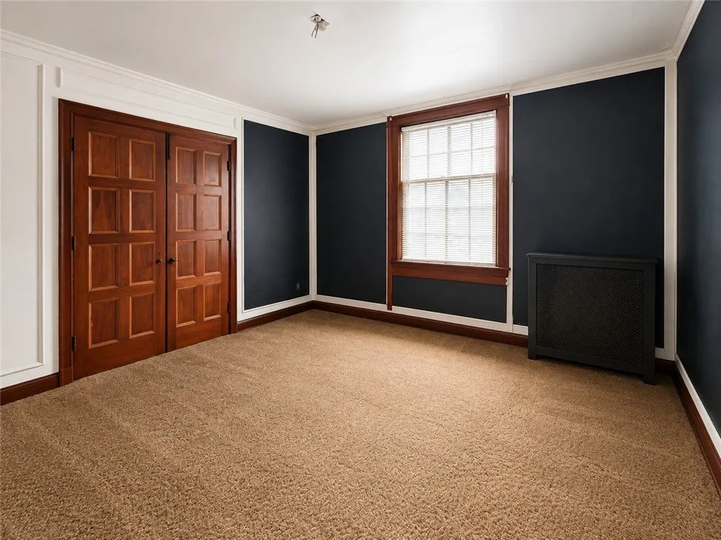The den from the bookcase end with a radiator under the window