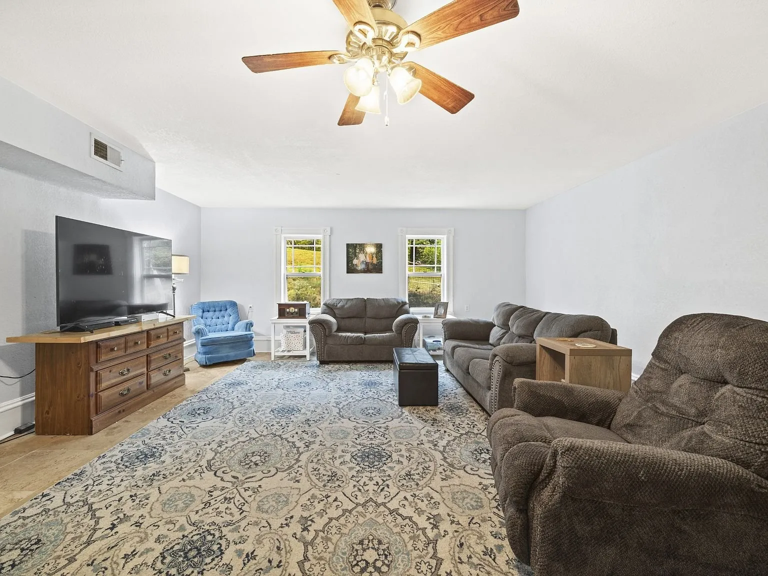 Family room with a ceiling fan and windows on two sides