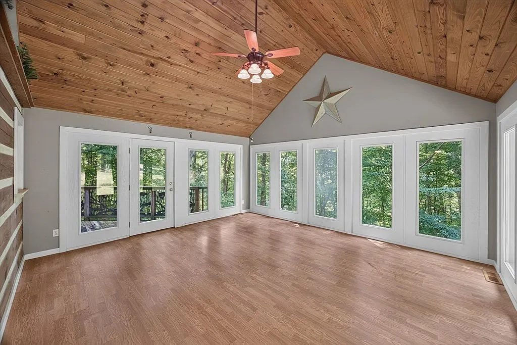 The vaulted family room with tongue-and-groove ceiling, wood floor and tall windows