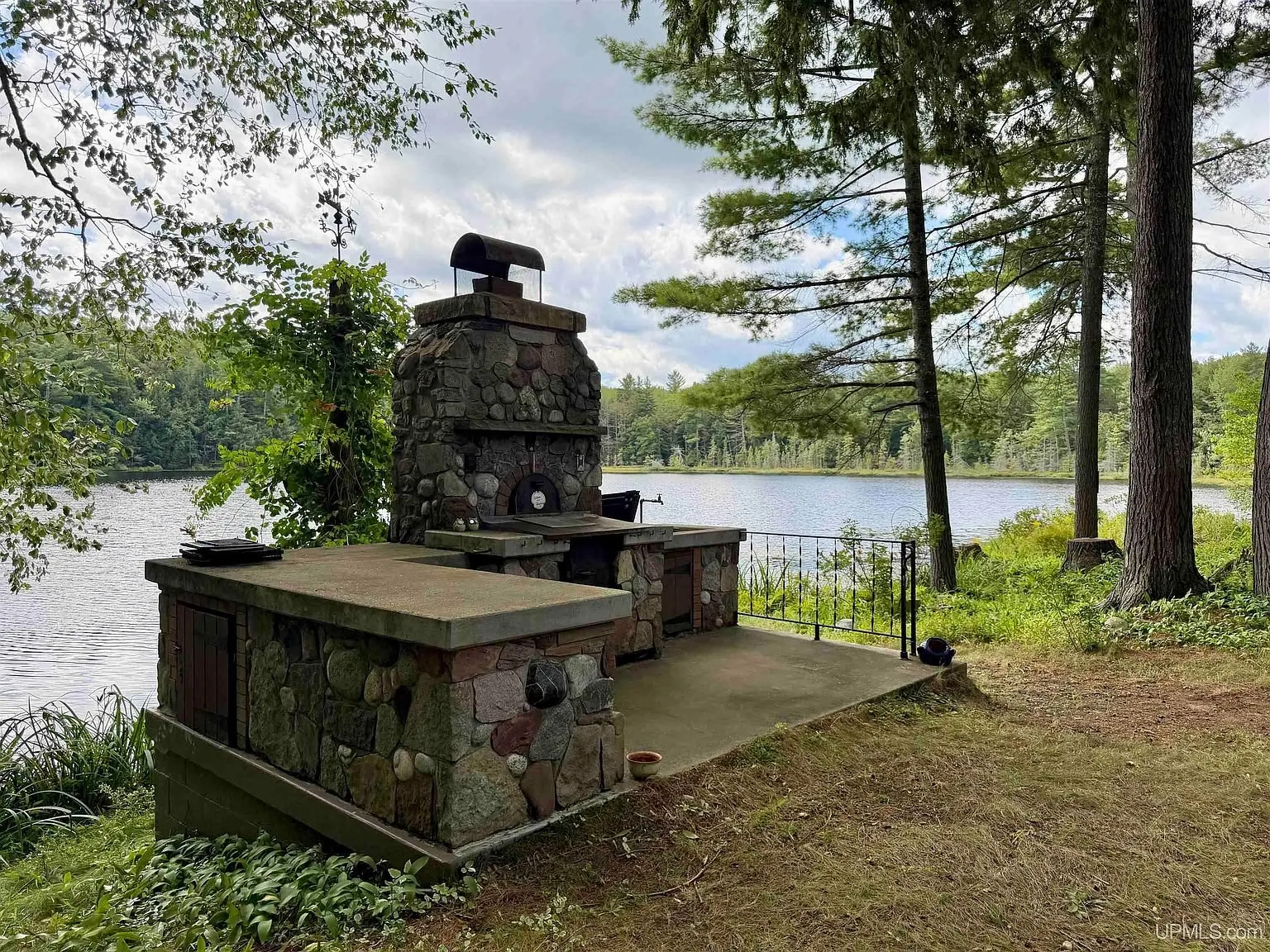 The stone outdoor fireplace and counter on the lake shore