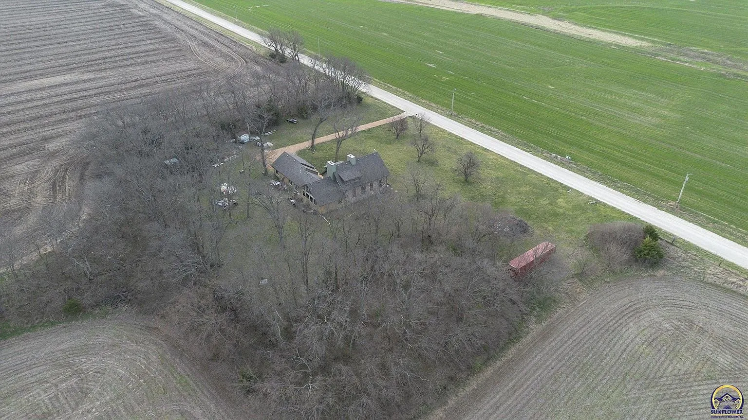 The wooded lot from high above with the farm fields around it