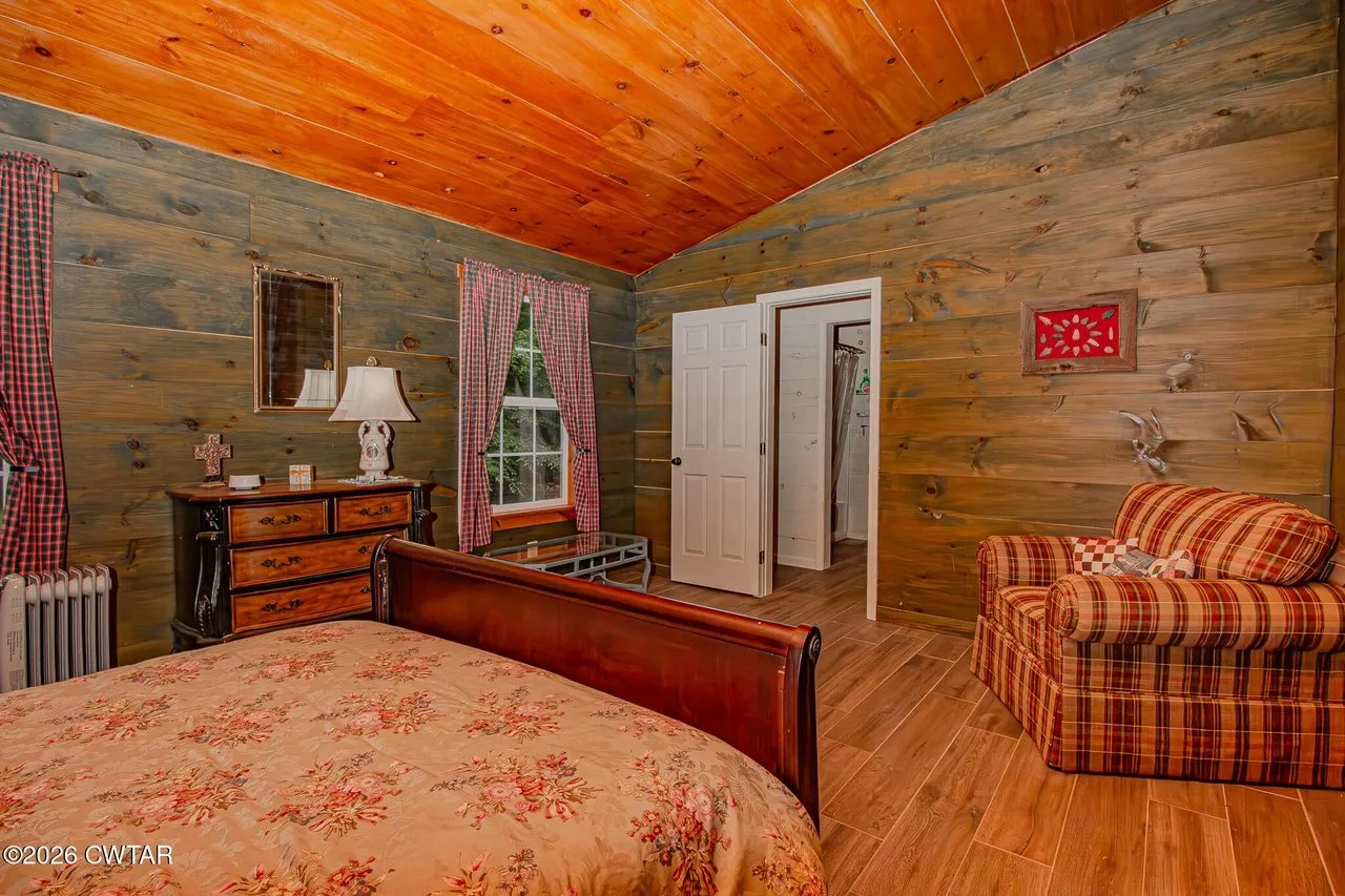 The same bedroom from the other side, dresser and a door to the hall