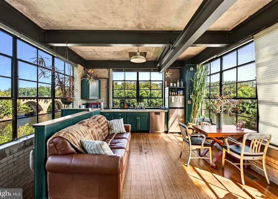 The living and dining area with leather sofas and a wood table
