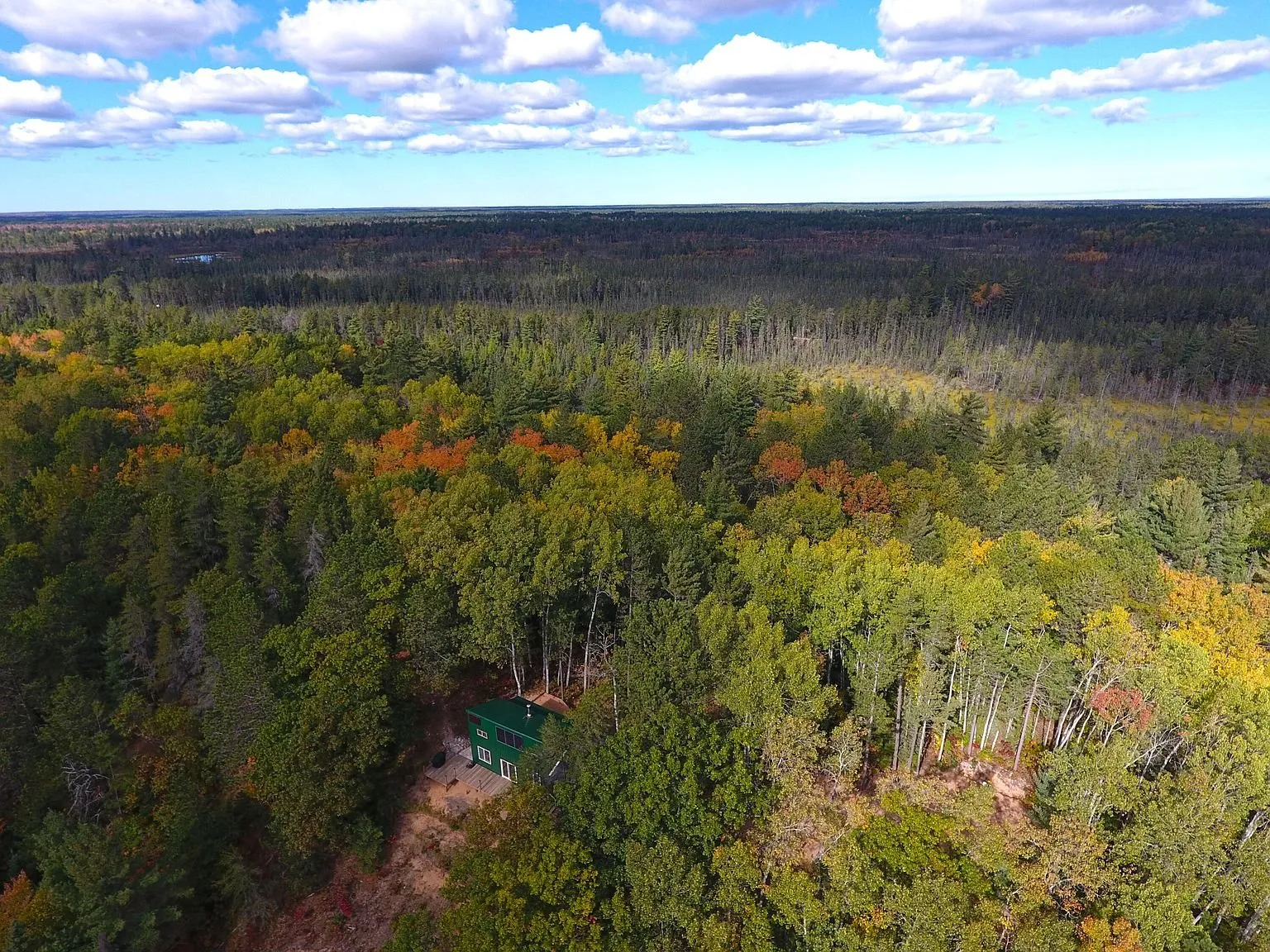 Aerial across the autumn forest from above the ridge