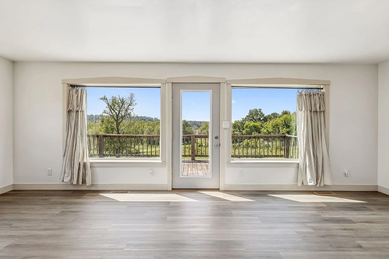The living room with the french doors and the windows onto the deck