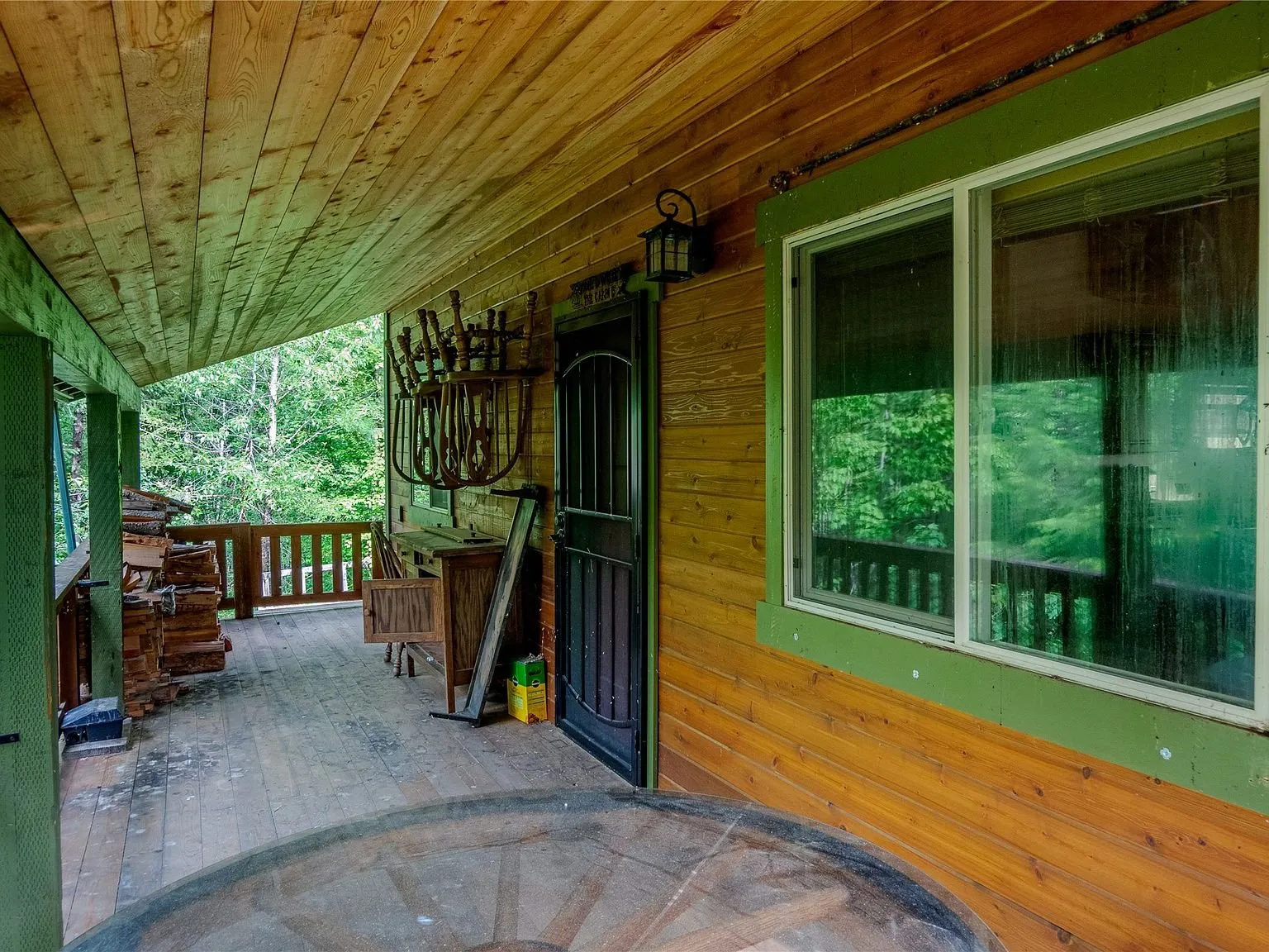 A second view of the covered porch looking toward the woods