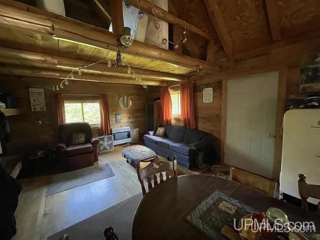 The main room with a couch, table and the door through to the kitchen