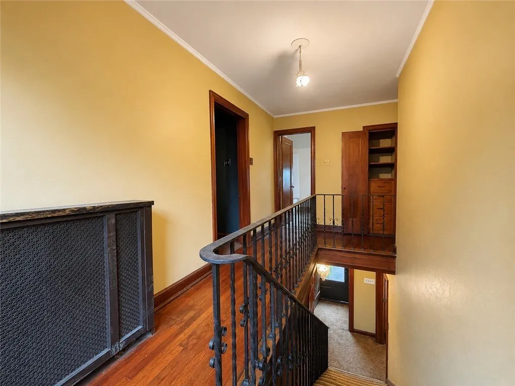 The upstairs hall with a radiator and the stair rail