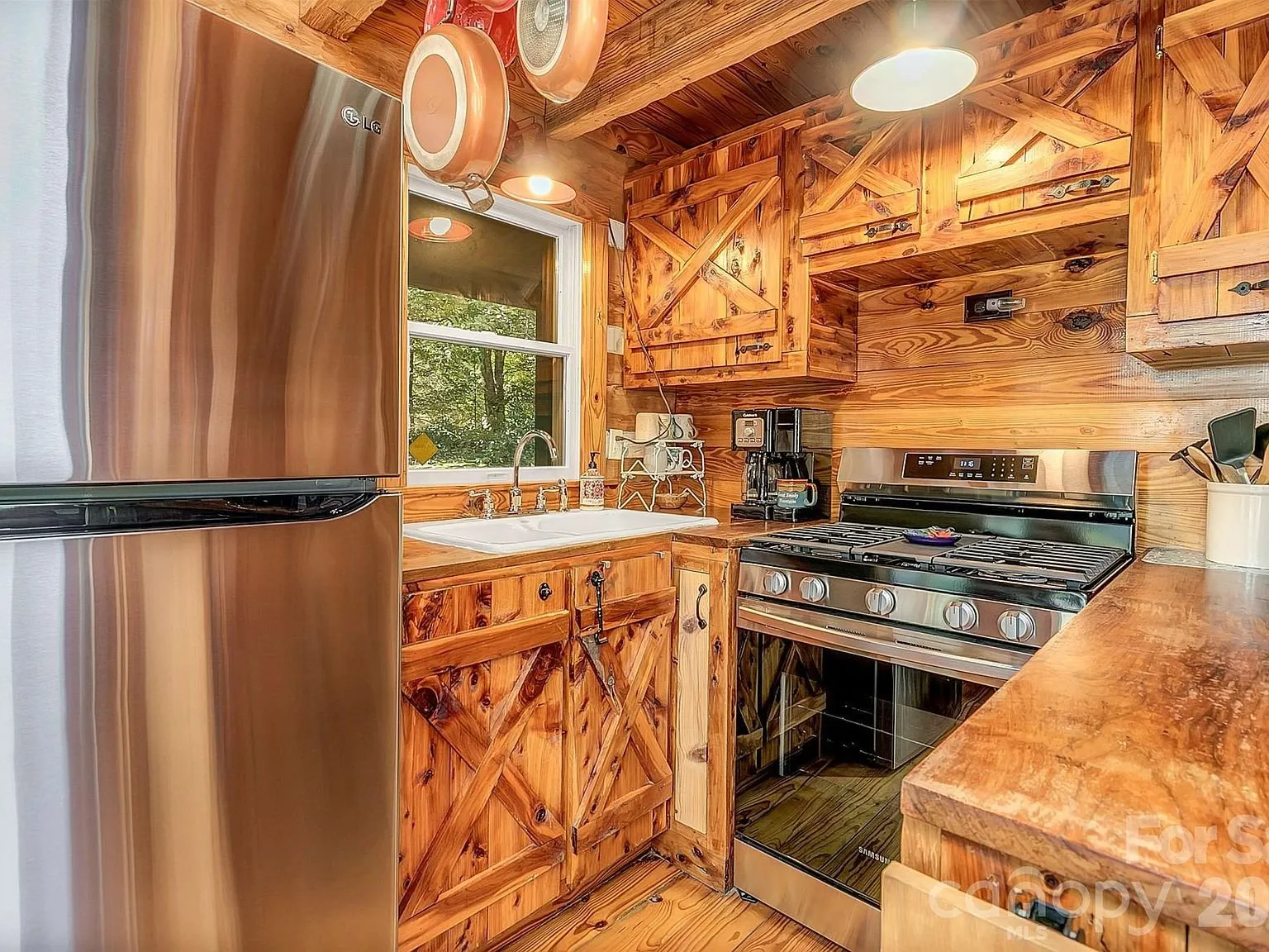 The kitchen's range and cabinetry along the log wall