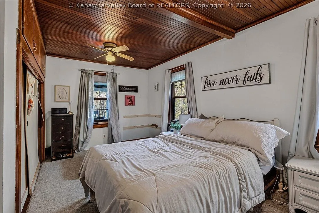 A second upstairs bedroom with band posters and a window AC unit