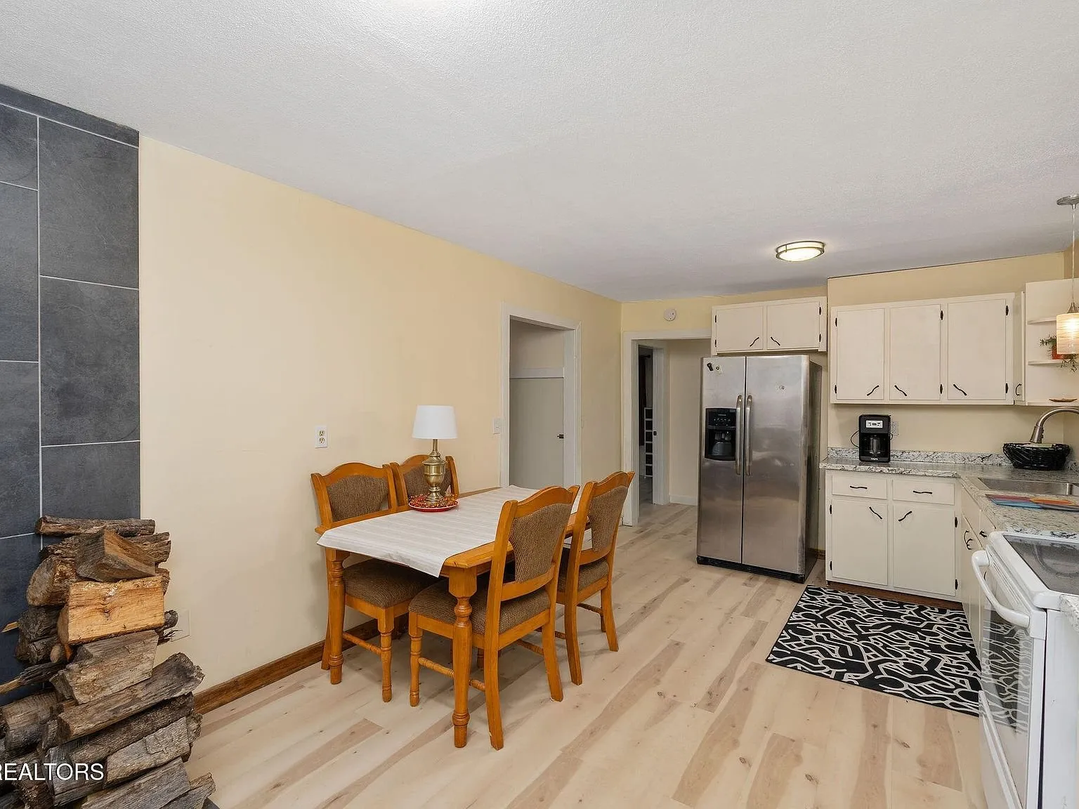 A closer view of the kitchen cabinets, counters and black appliances