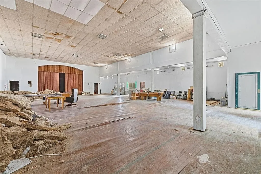 The auditorium from the side with the stage, the columns and the piles on the floor