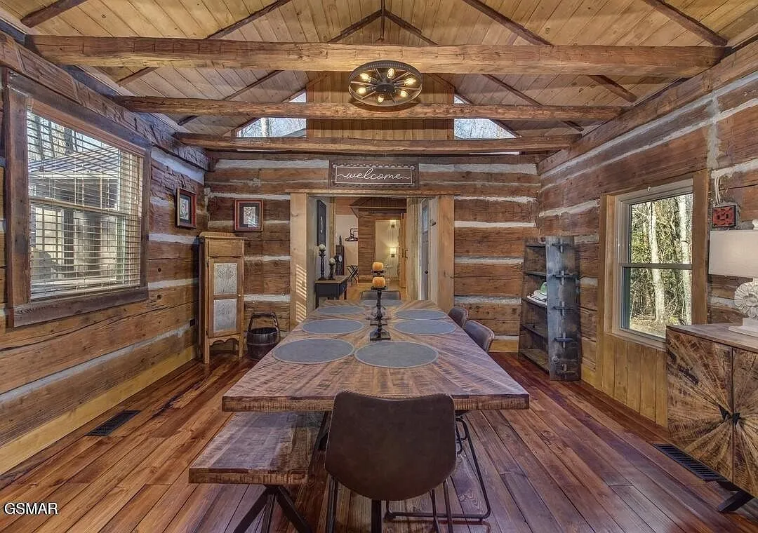 The long dining table under a low log ceiling in one of the historic rooms