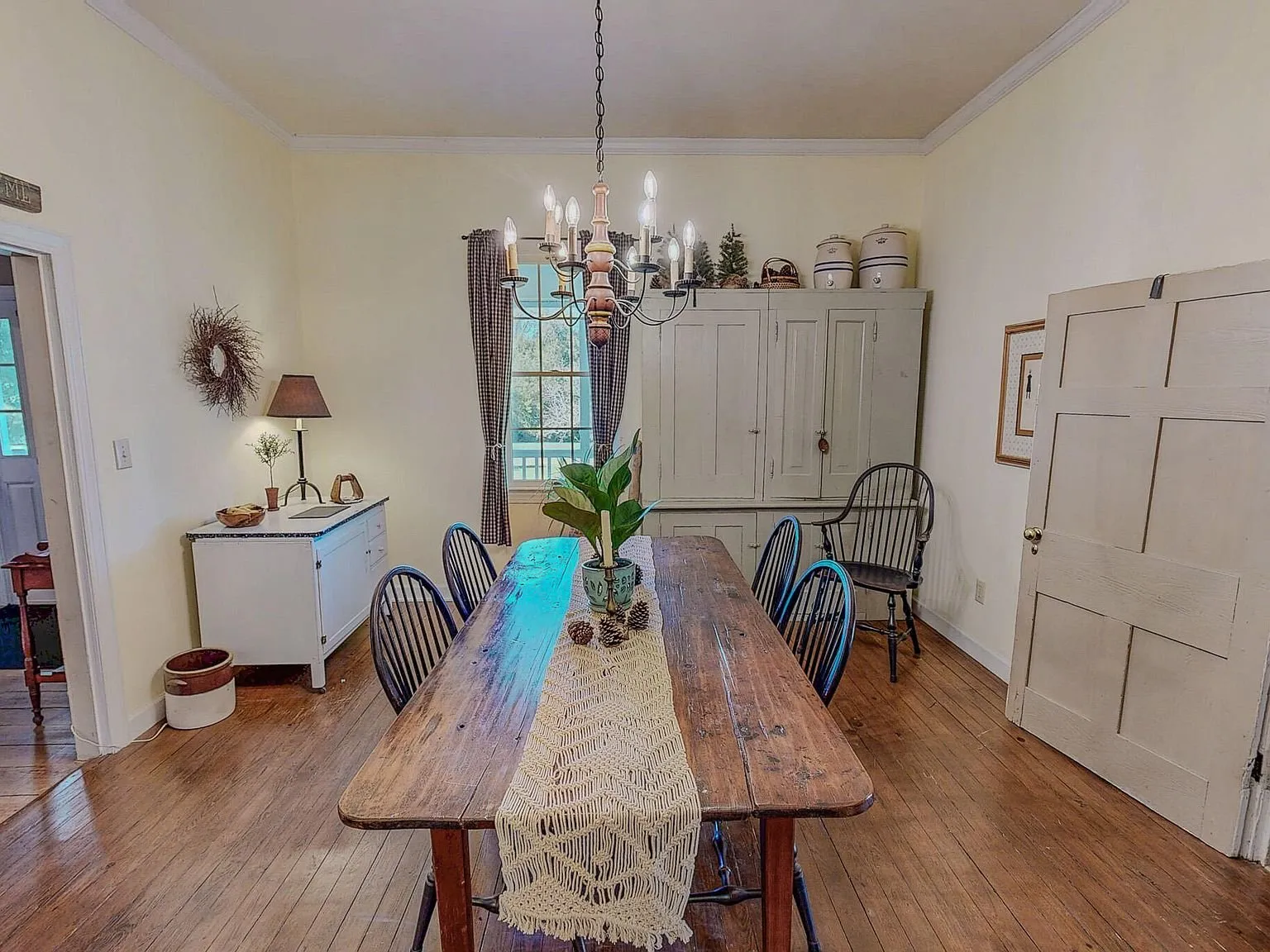 A second dining room with a runner-topped table and built-in corner cabinets