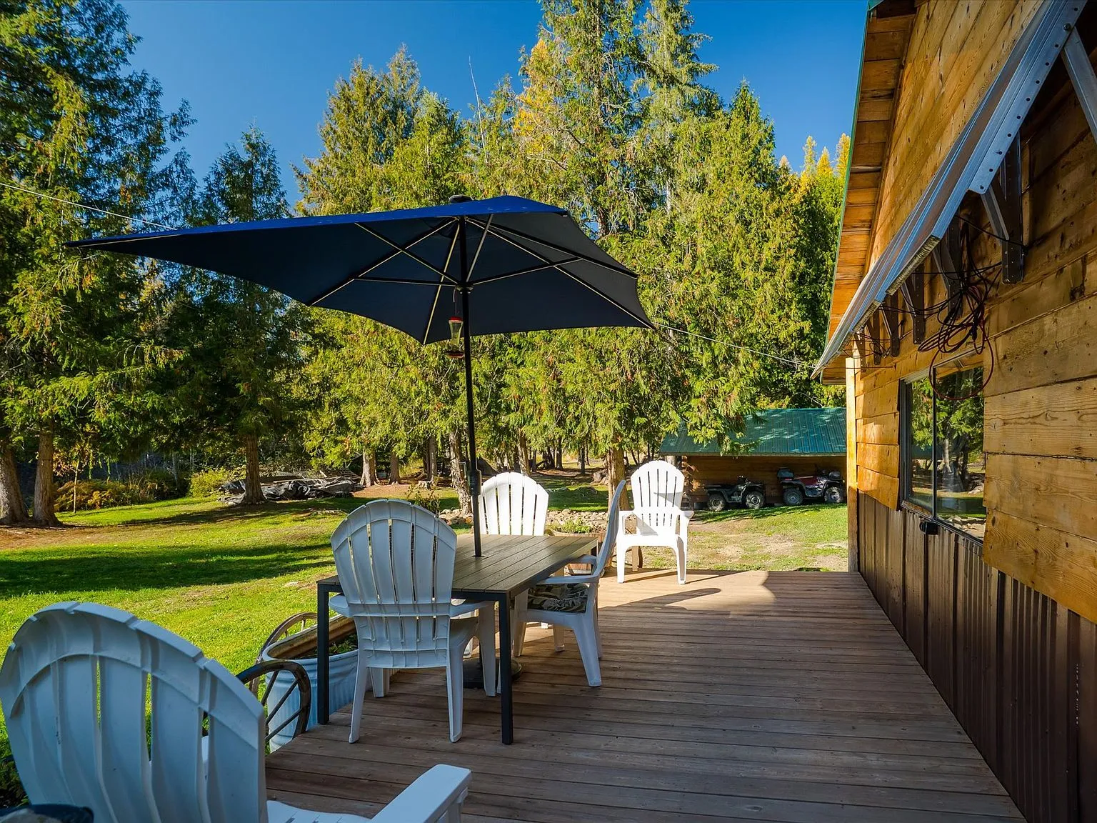 The cabin's solar-paneled roofline and covered porch, with an RV parked alongside