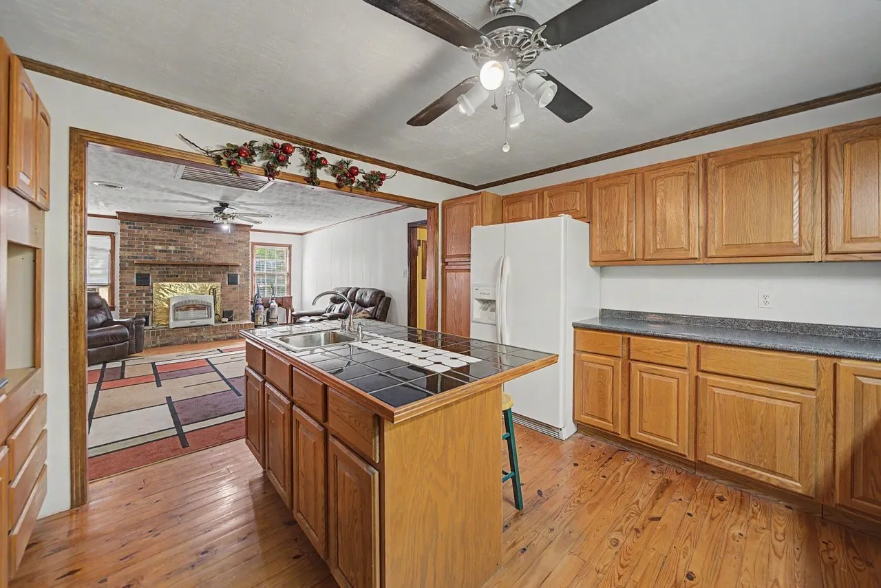 The kitchen from the far end, cooktop in the island and a pass-through