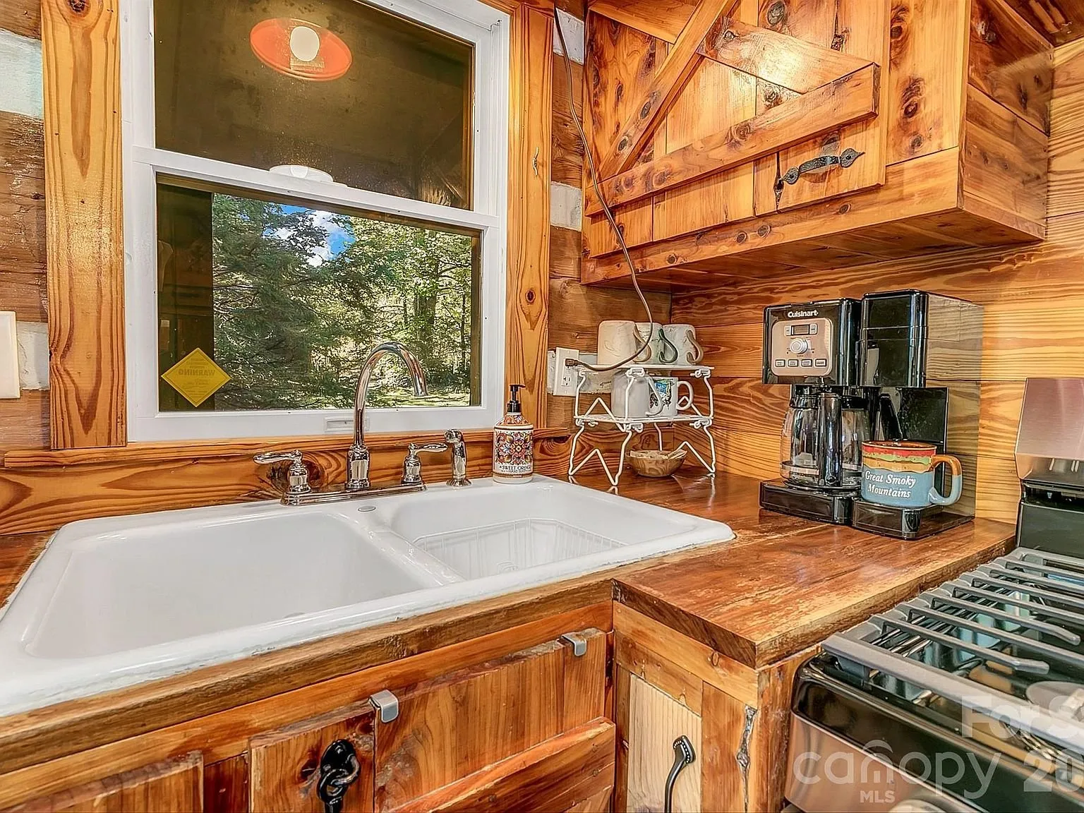 The kitchen sink and coffee station under a window