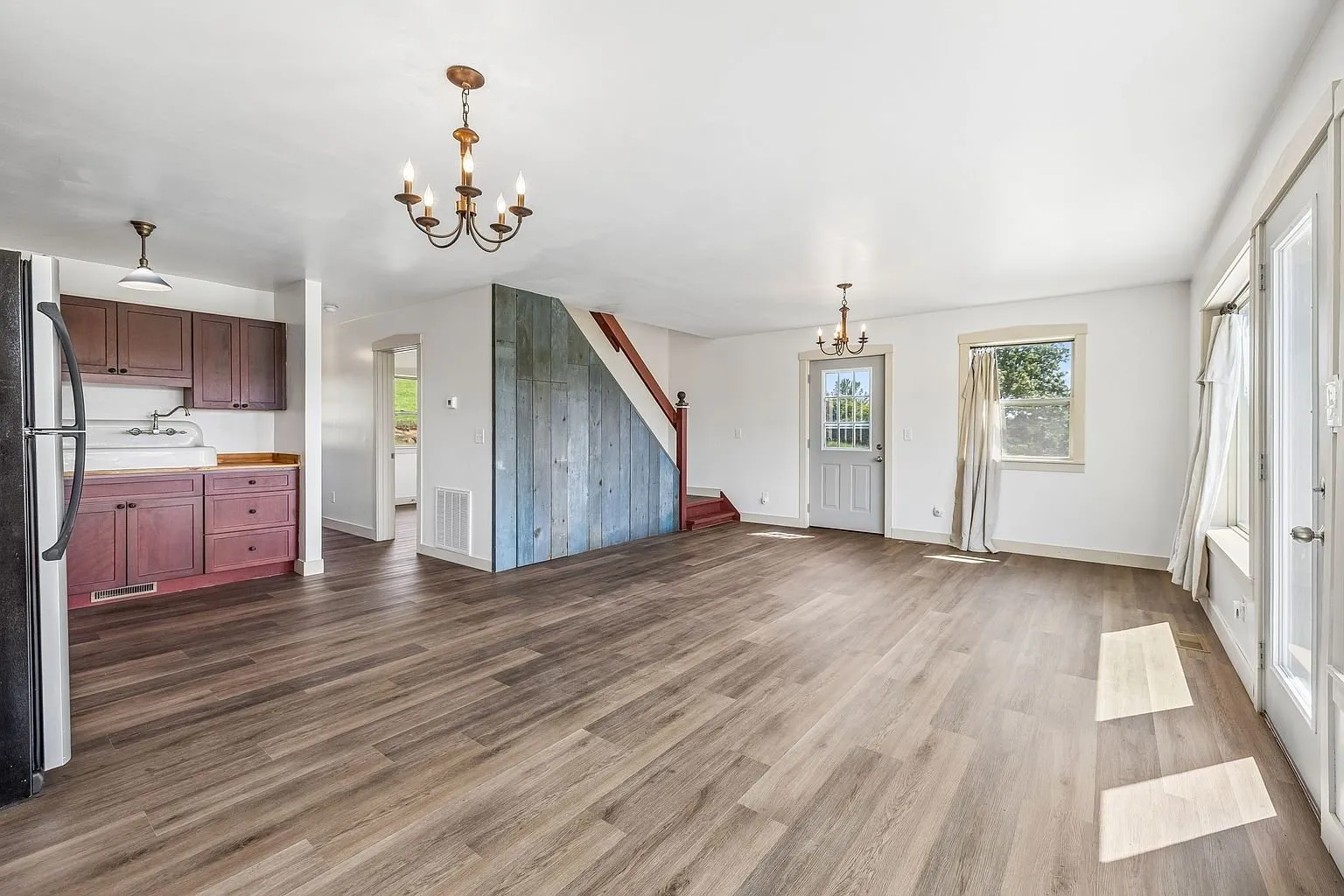 The open main room with the kitchen, the stair wall and the laminate floor