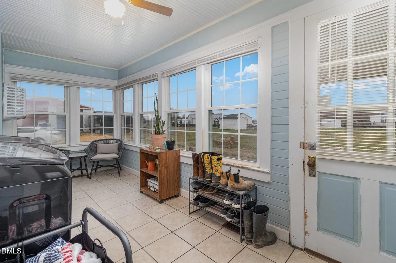 The sunroom: windows on three sides, tile floor and a wood stove