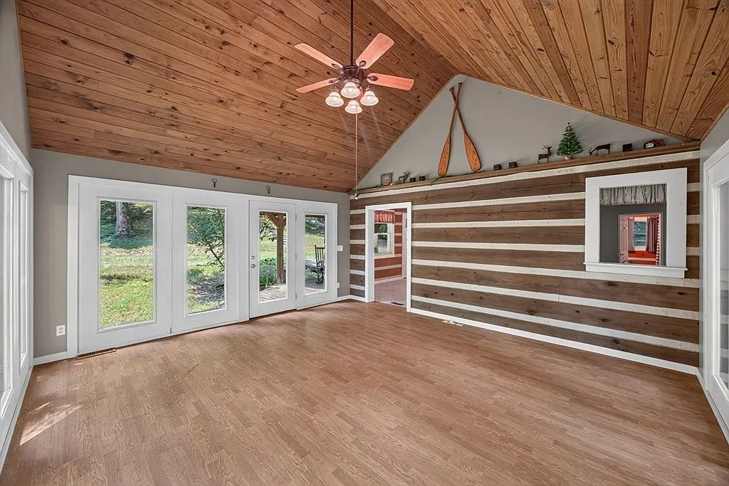 A second angle of the vaulted family room showing the log accent wall