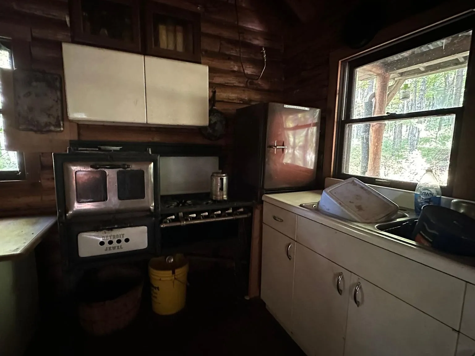 The antique cook stove and oven beside the kitchen window
