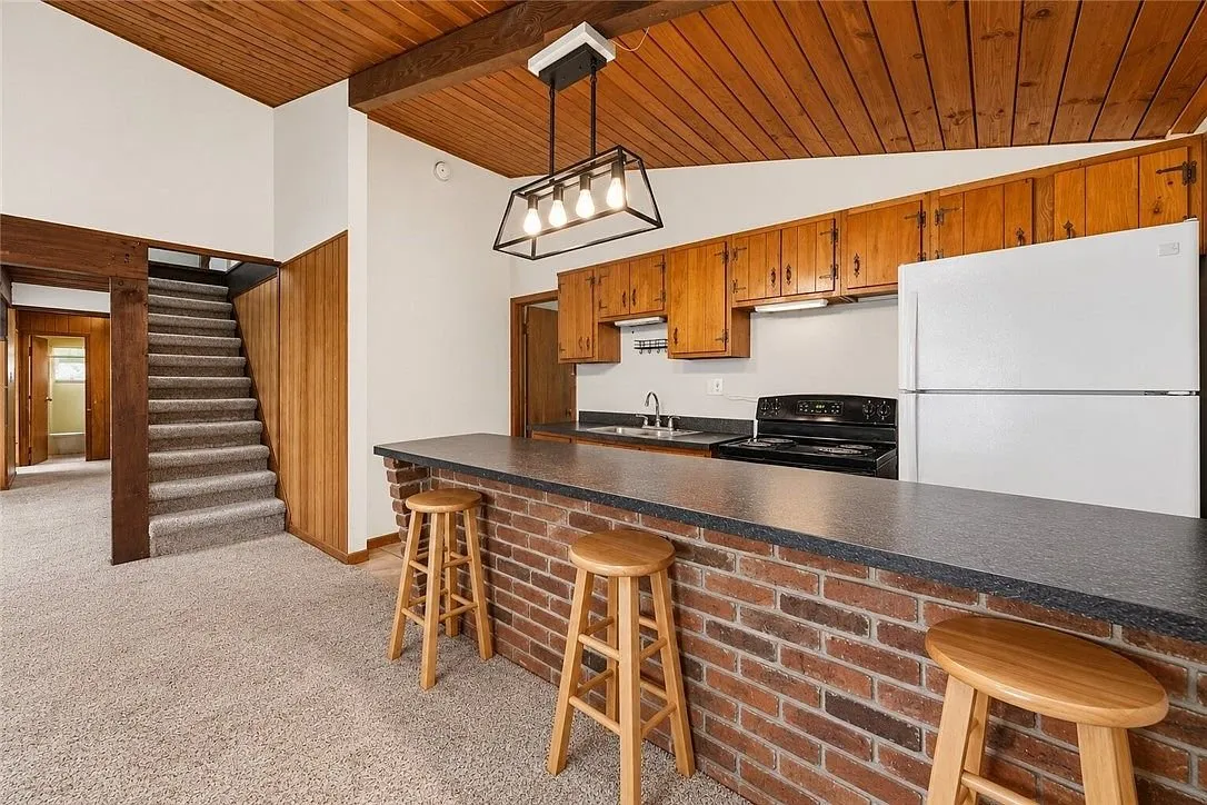 The kitchen and dining area together beneath the vaulted ceiling