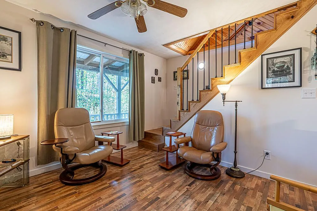The living area with leather recliners, hardwood floors and the stairway to the loft