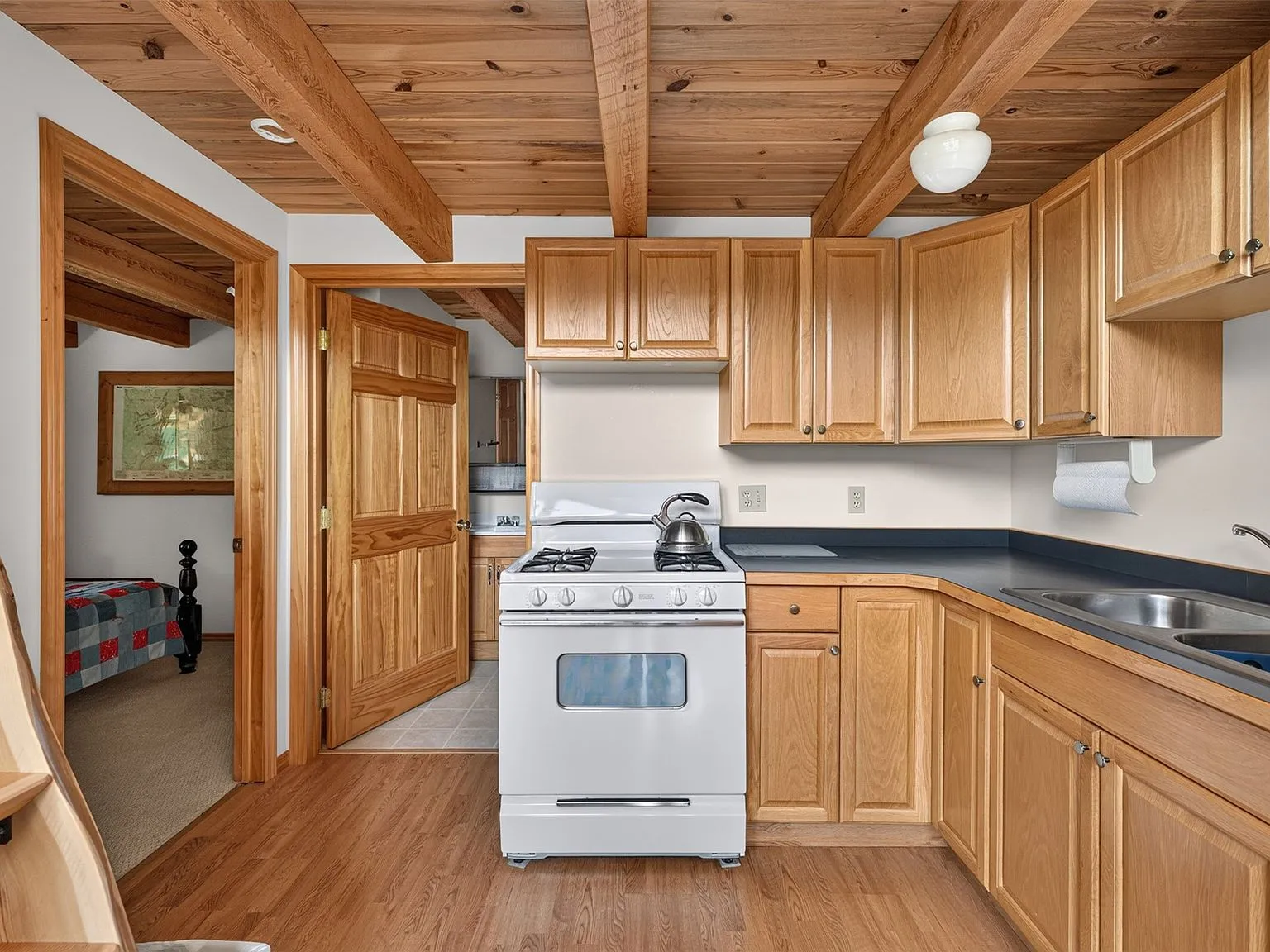 The kitchen with a propane range, oak cabinets and open shelving