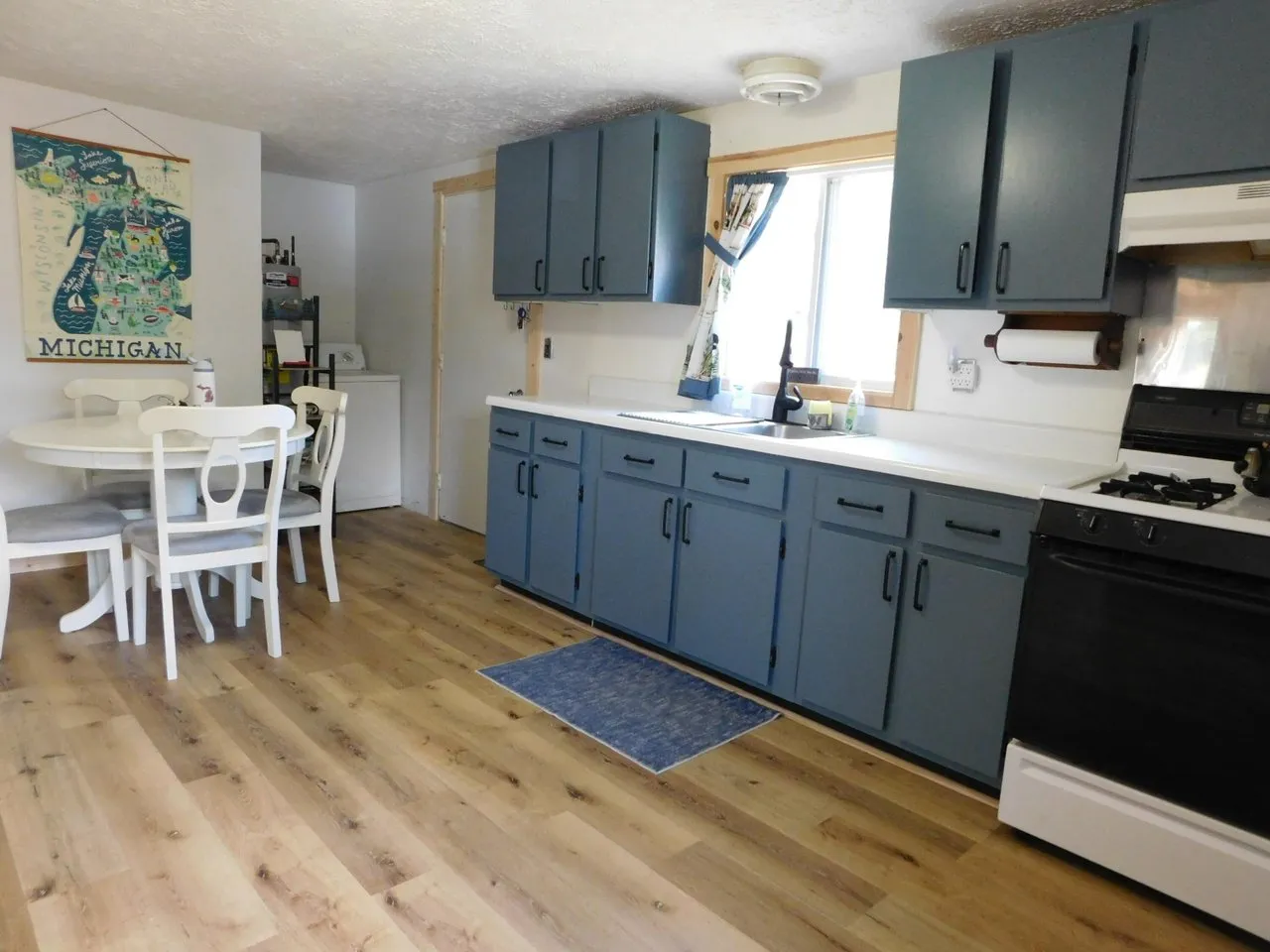 The kitchen with blue cabinets, gas range and refrigerator