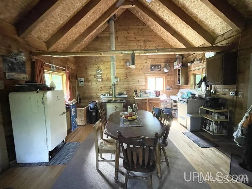 The kitchen and dining table under the peaked log ceiling