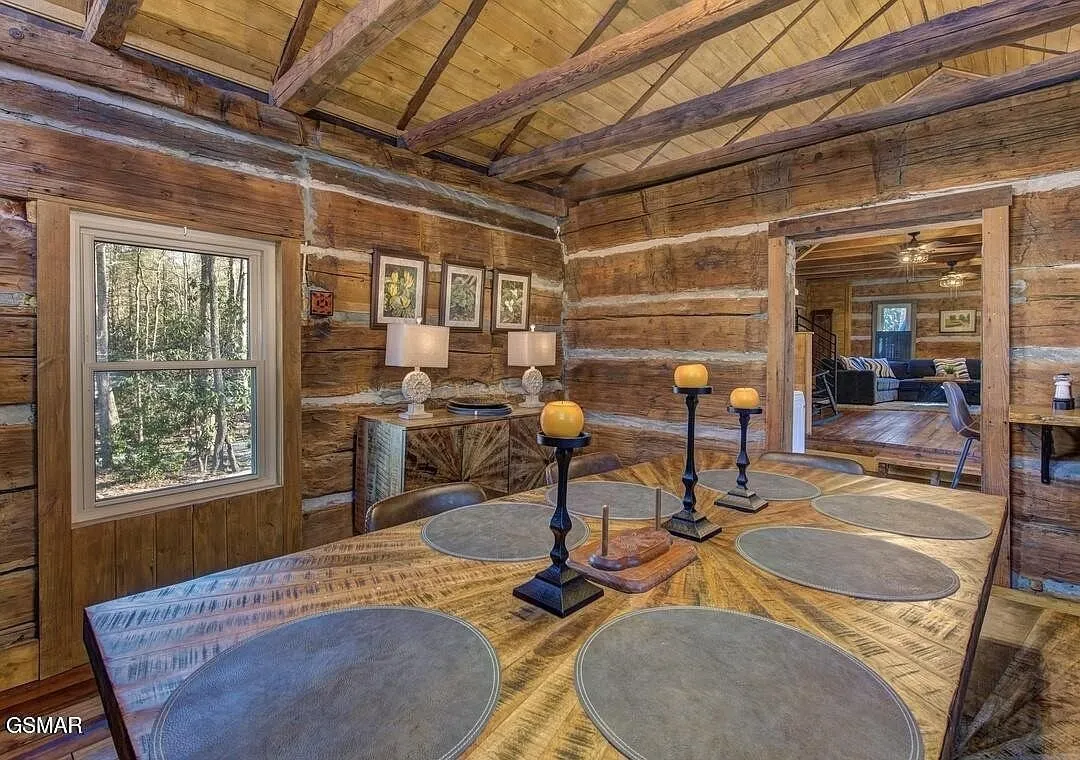 A sitting room with candles on the table and log walls