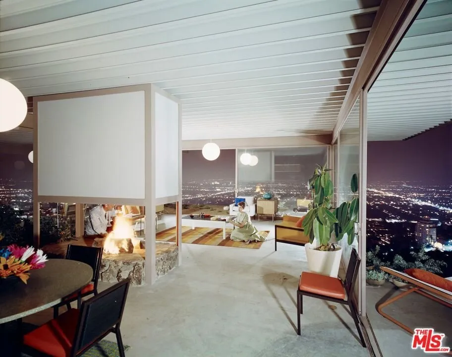 The fireplace lit, seating and the terrace glass beyond