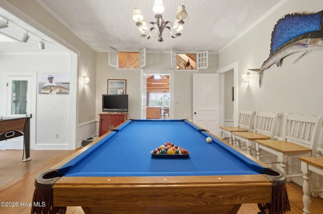 The game room with a pool table and a long dining table