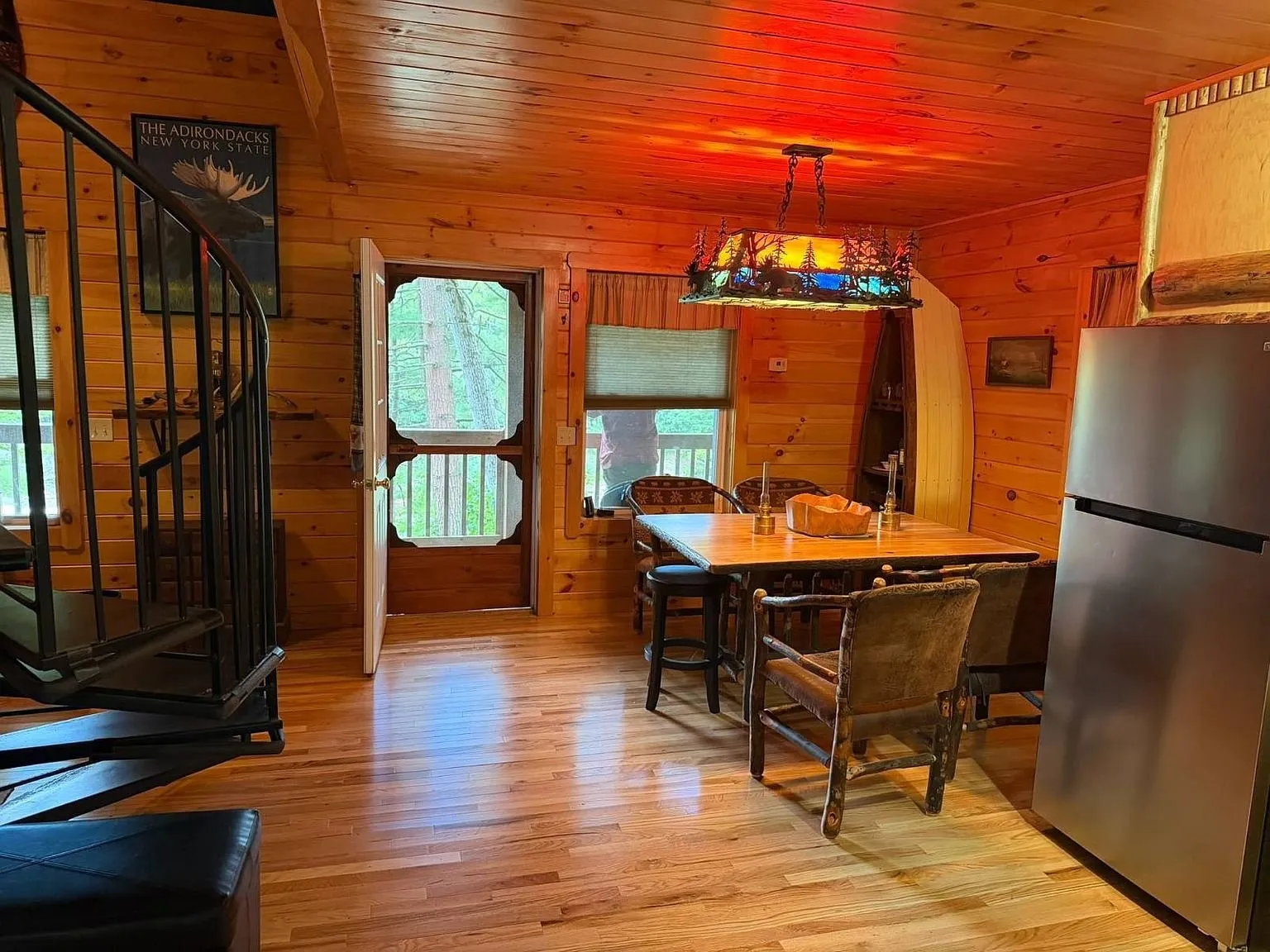 The kitchen and dining area with the table, the refrigerator and the spiral stair