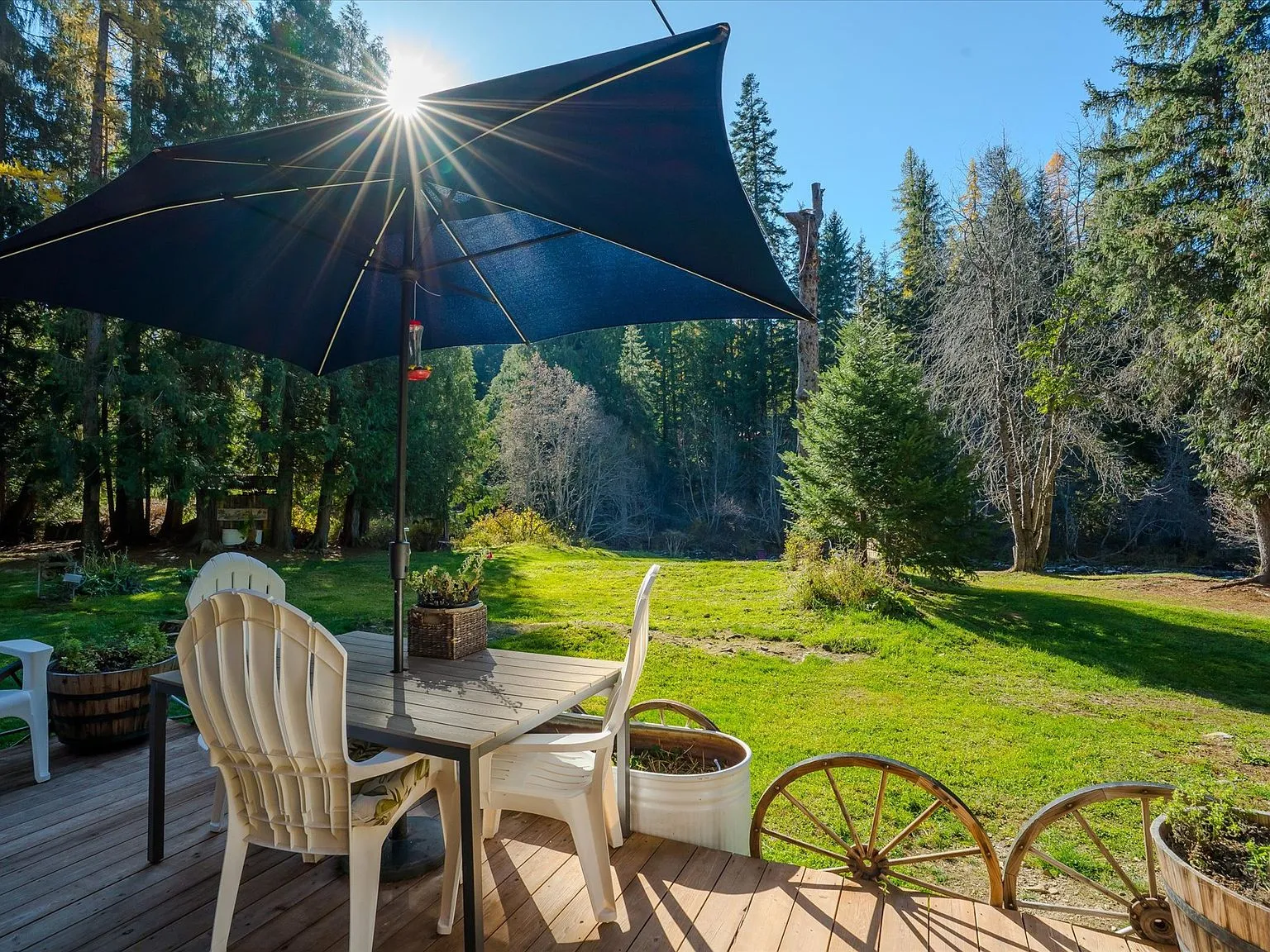 A wide view of the cabin, porch and parked RV nestled among the pines