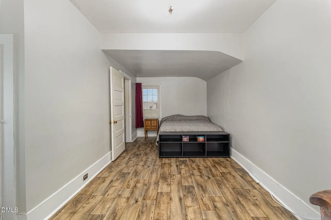 The bonus room, long and narrow with a sloped ceiling and laminate floor