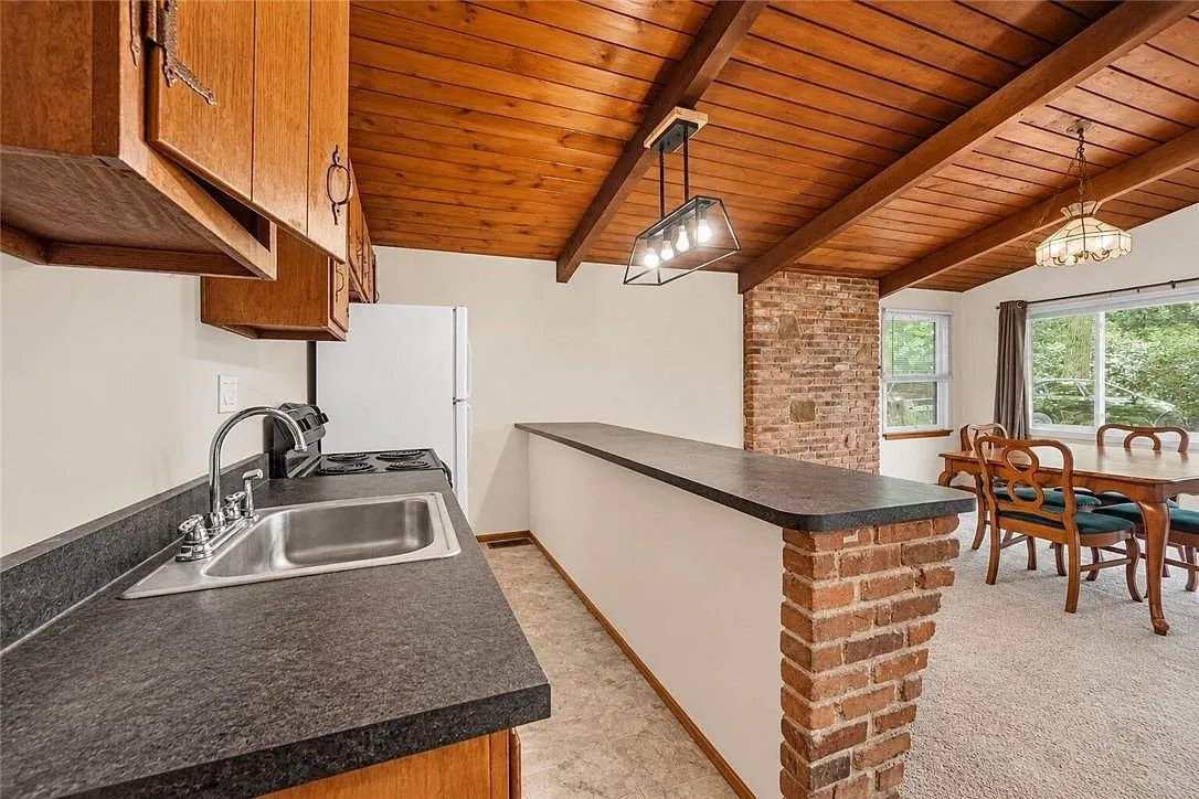 The wood-paneled wall between the kitchen and the great room