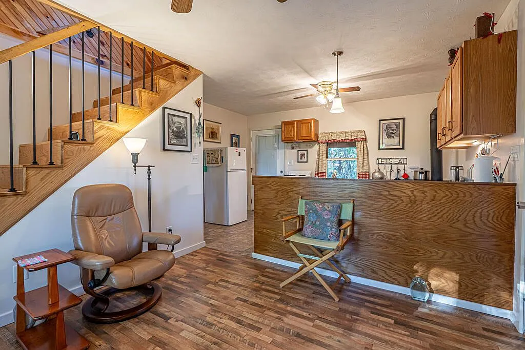The living room and kitchen bar seen from beside the stairway