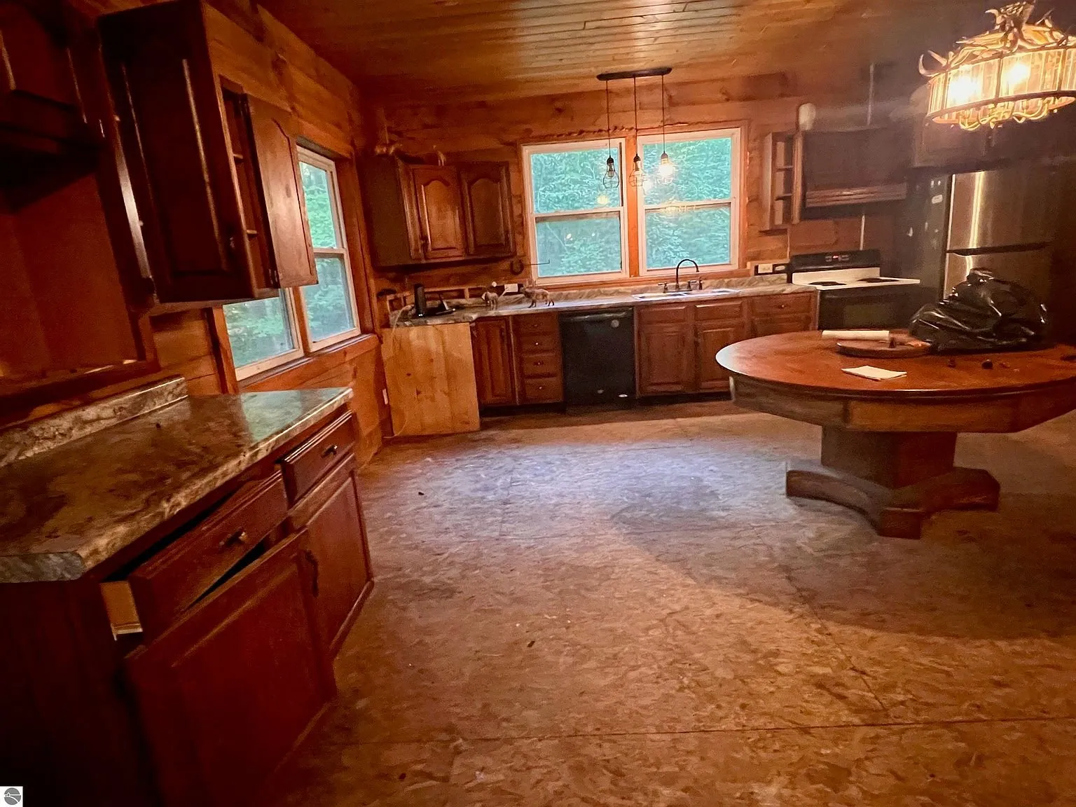 The kitchen with the cabinets, the round table and the window over the sink