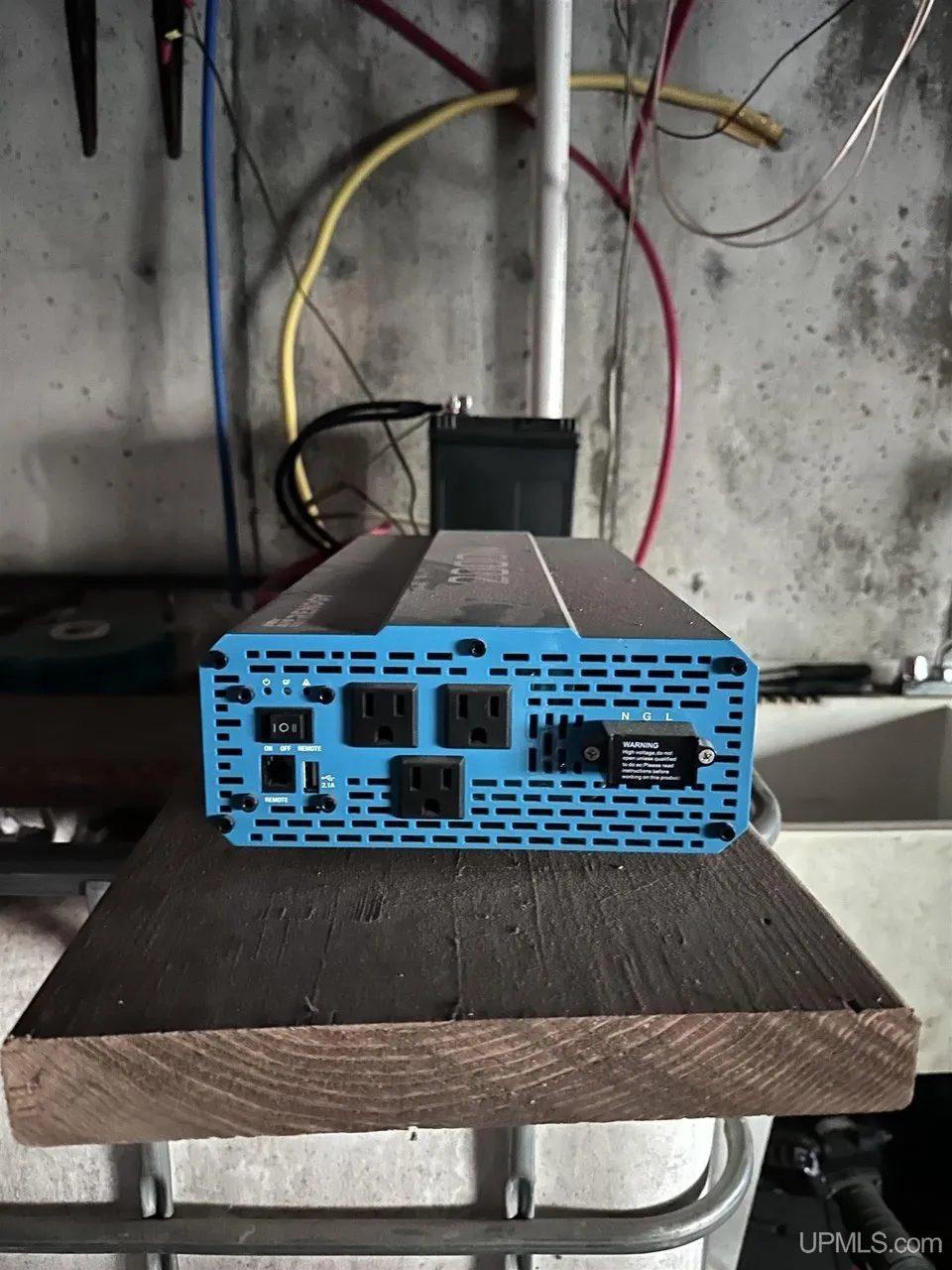 The power inverter on a plank against the basement wall