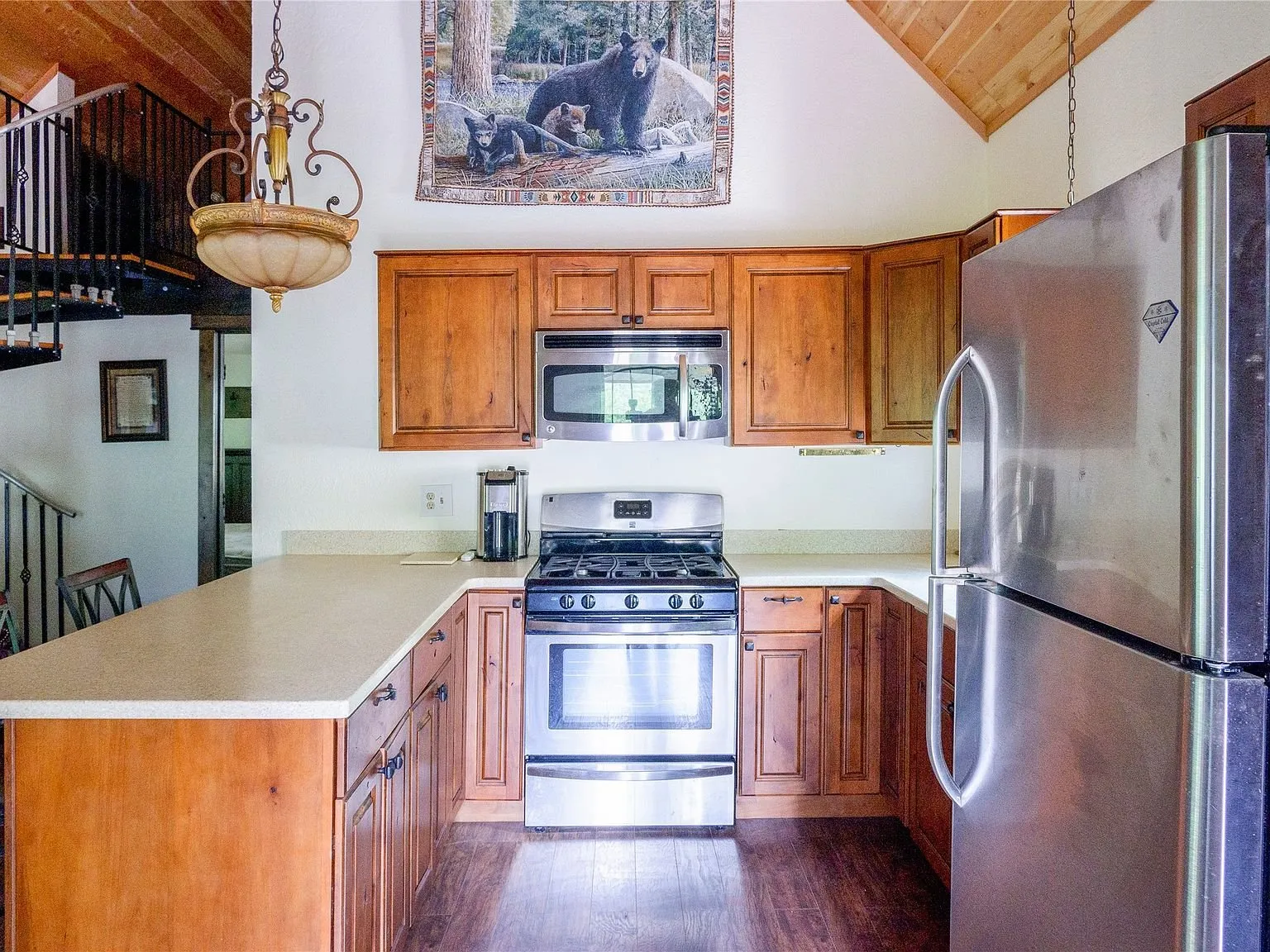 The kitchen seen from the dining side, cabinetry and window over the sink