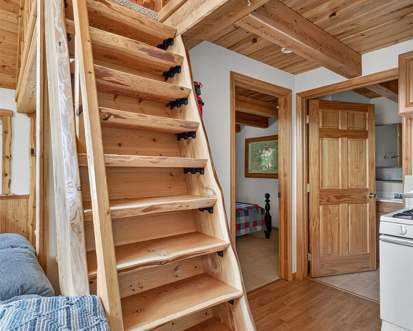 The kitchen and staircase, with the bedroom door visible beyond