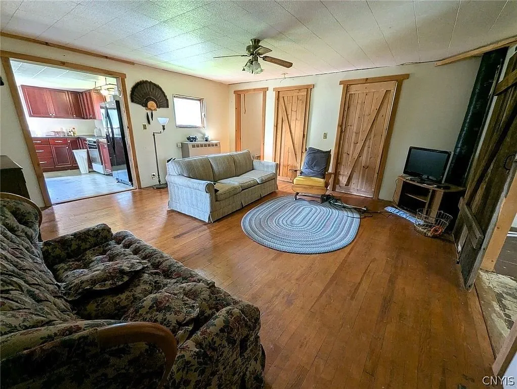 The living room with two sofas, a braided rug and the barn doors