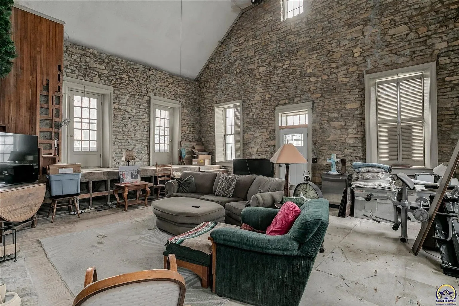 The schoolhouse great room with its stone walls, tall windows and vaulted ceiling