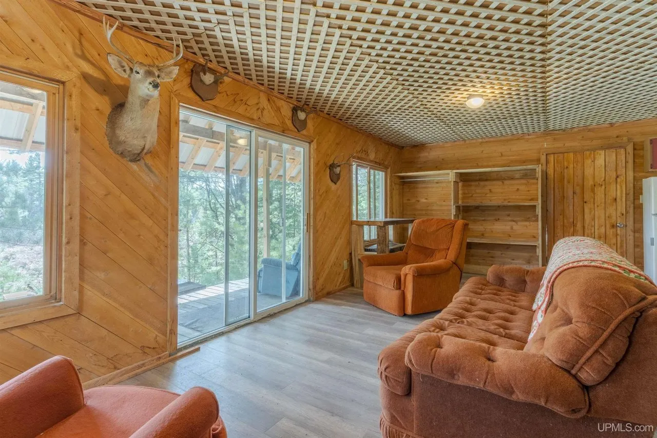 The living room with a mounted deer head above the sliding door