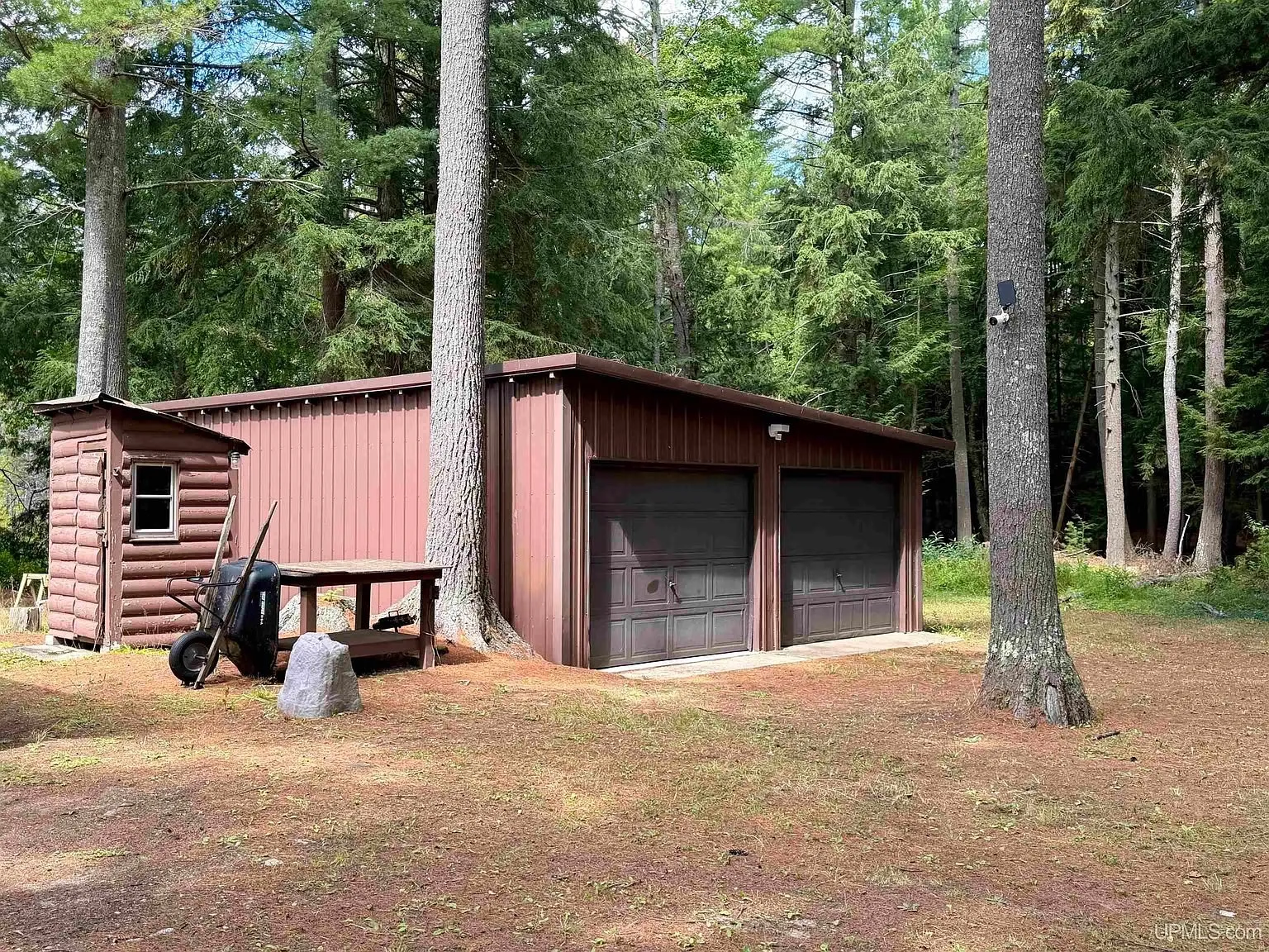 The detached two-car garage under the pines