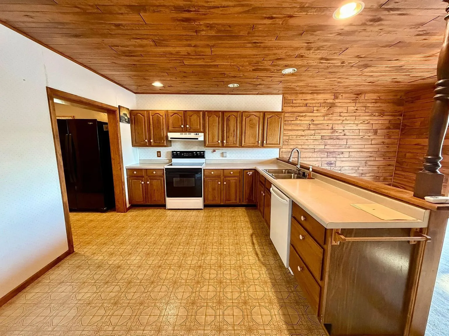The kitchen with the oak cabinets and the white appliances