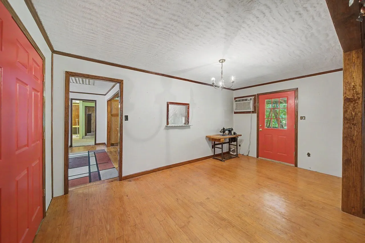 A room with two red doors and a window onto the yard